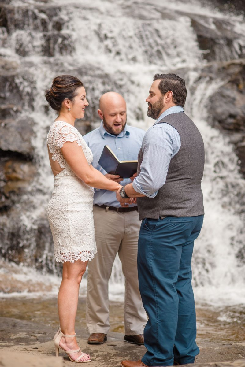 bride in short lace dress. Elopement at waterfalls