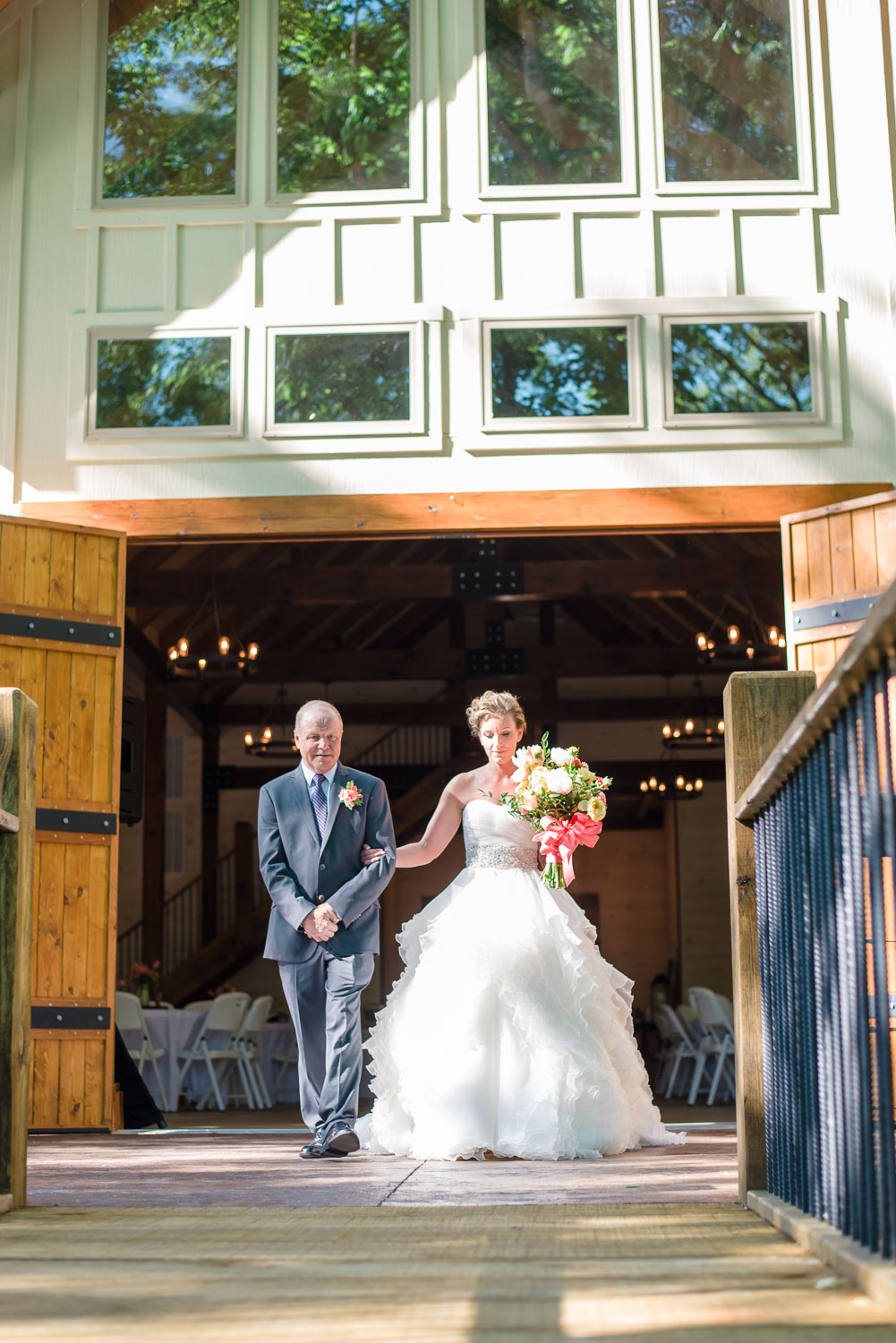 dad walking bride out of the Timber frame event center on her wedding day