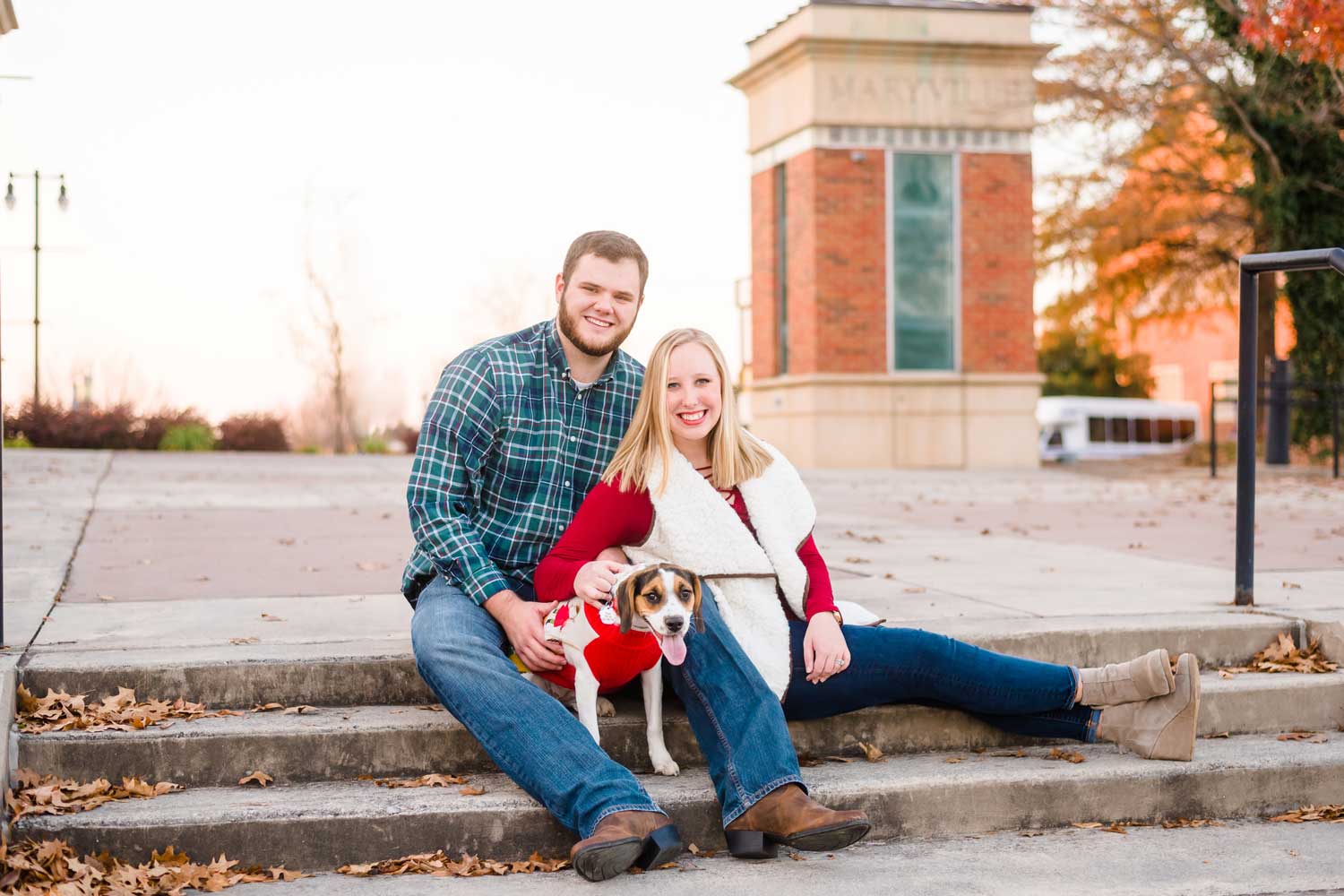 couple with their beagle dog sitting on steps in downtown Maryville for Christmas family photos