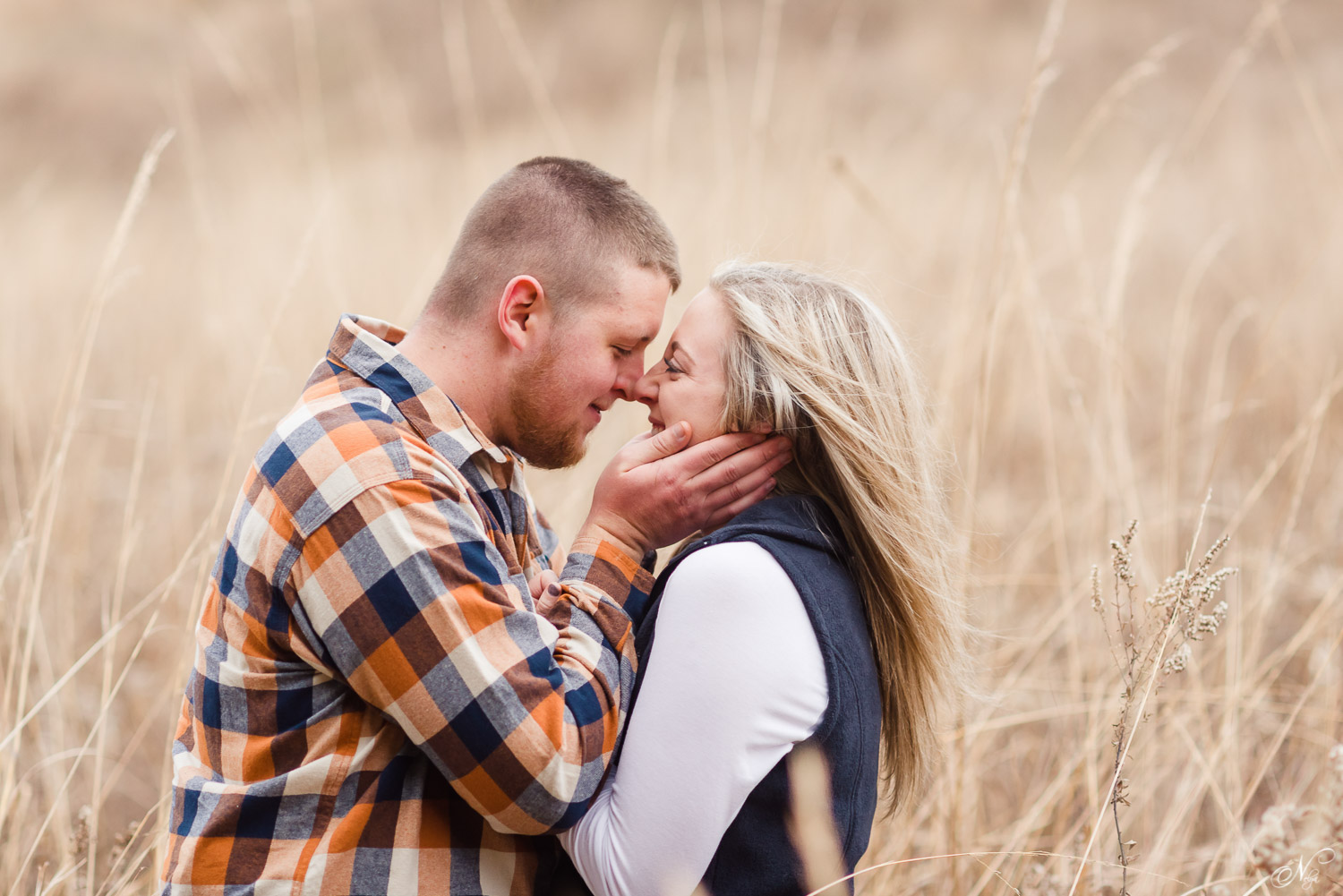 engaged couple standing in tall brown grass in Knoxville TN