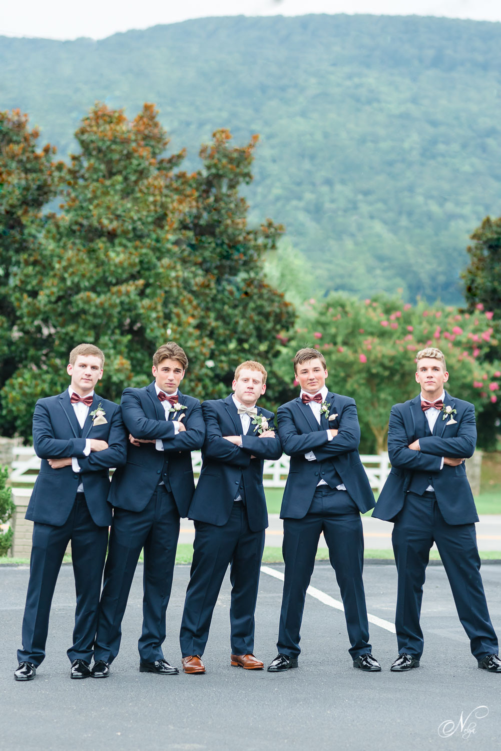groomsmen all standing outside with their arms crossed giving their best GQ looks.