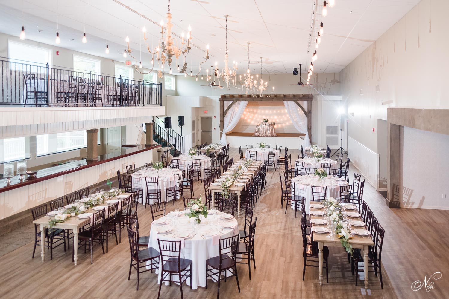 wide angle view of fully decorated wedding reception at The Venue Chattanooga with chiavari fruitwood chairs and white linens