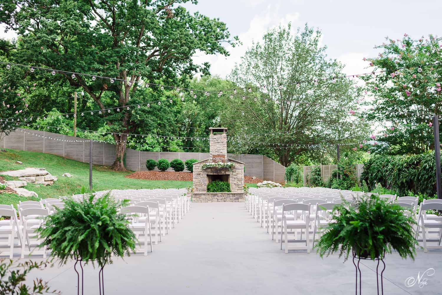 The garden ceremony option with ferns at the entrance to the aisle and all white chairs at the Venue Chattanooga in Tennessee.