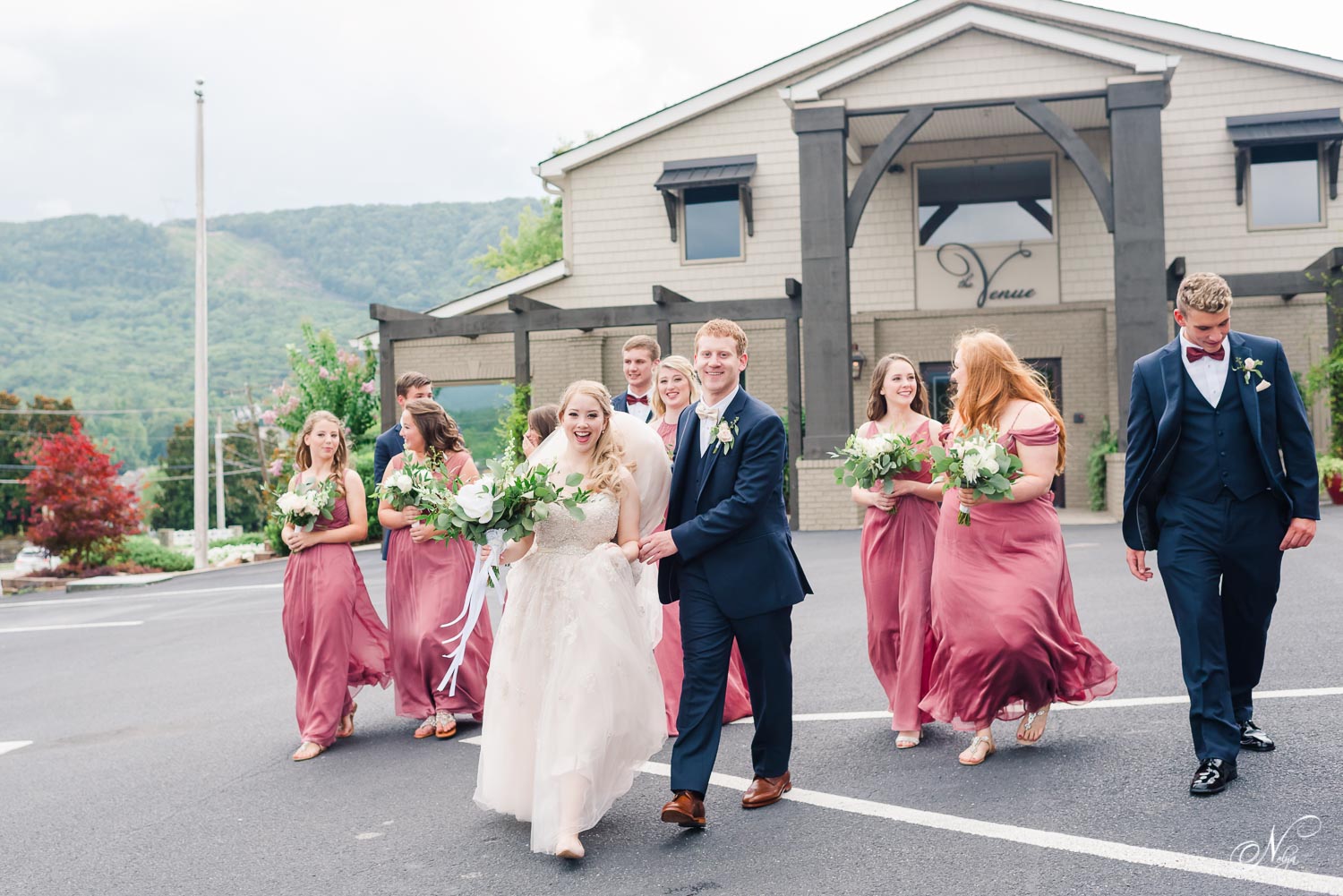 bride and groom running into the wind with bridal party behind them in Chattanooga TN