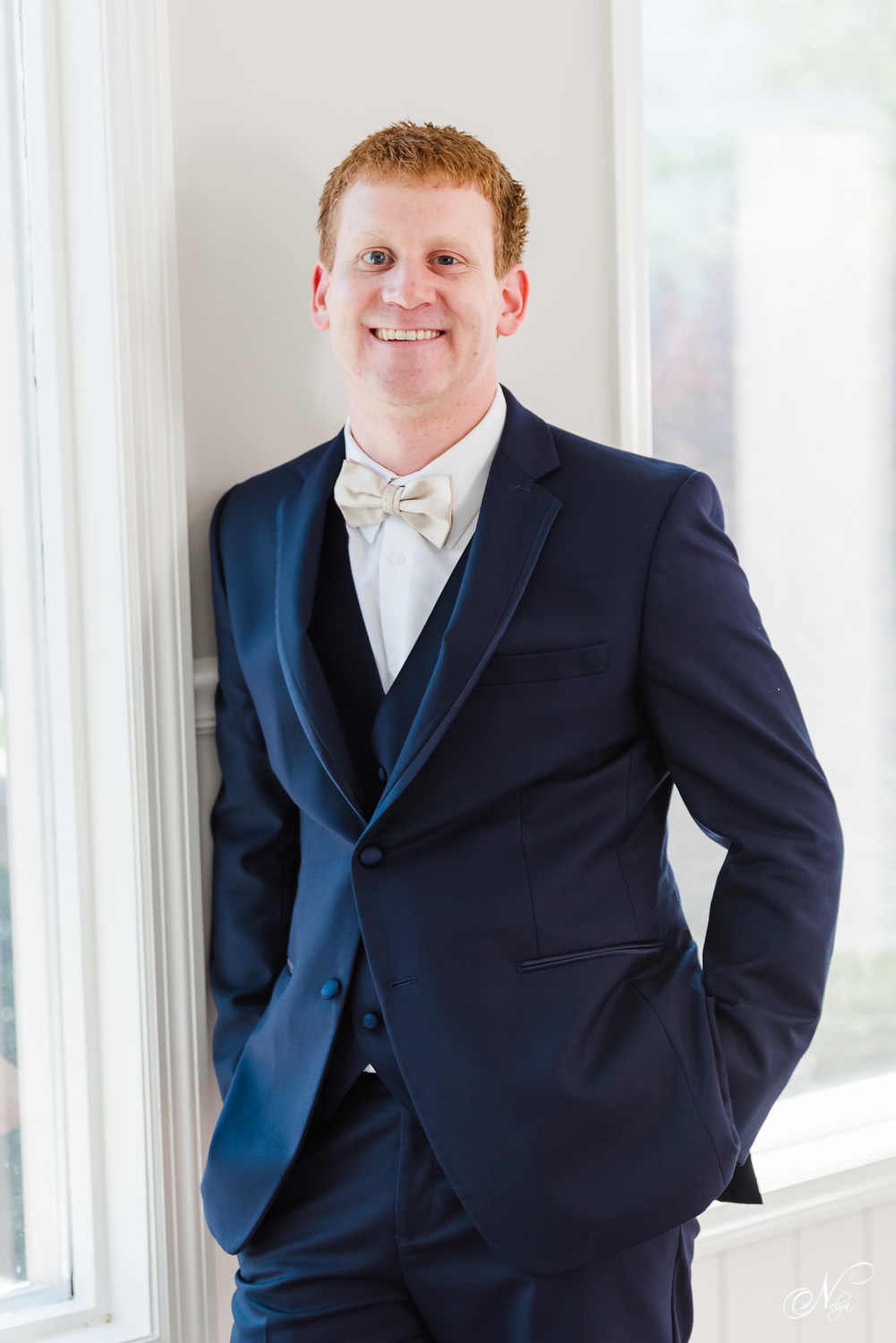 red hired groom in navy blue suit smiling