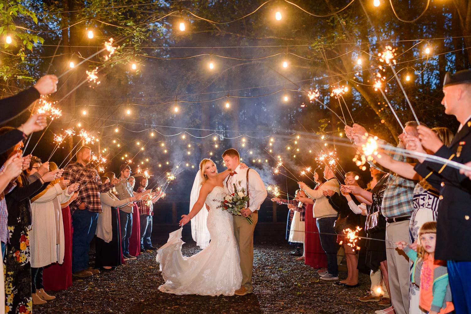 Nelya Photographer night time wedding sparkler exit under twinkly lights at Hiwassee River Weddings