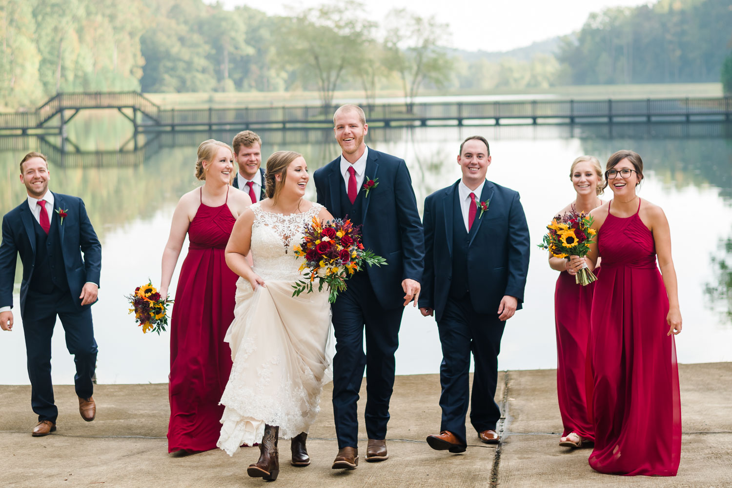 wedding party in red, white and blue walking in front of pond at Indigo Falls venue near Atlanta GA