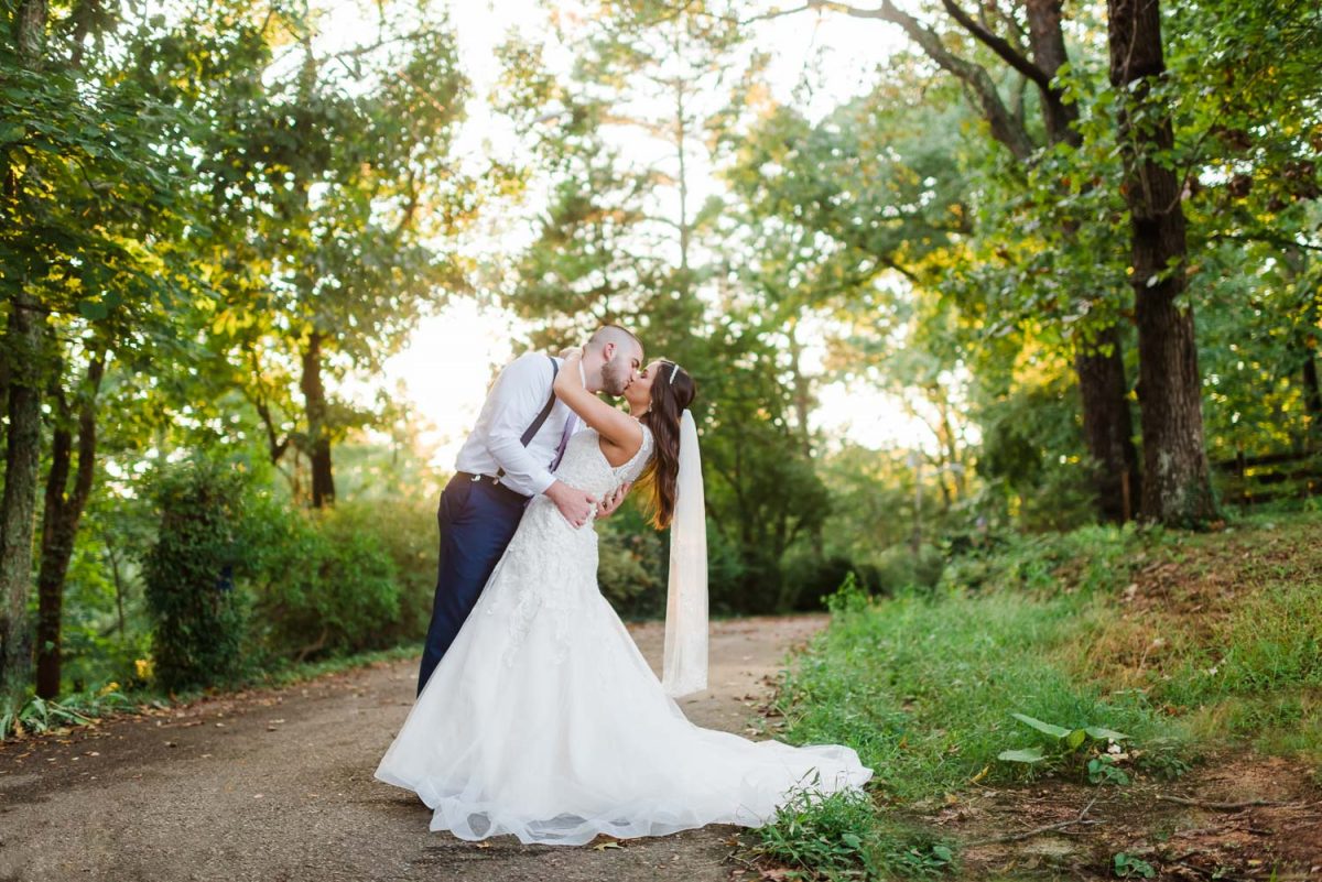 wedding couple outside at sunset in Knoxville TN with sunlight coming through the trees onto them.