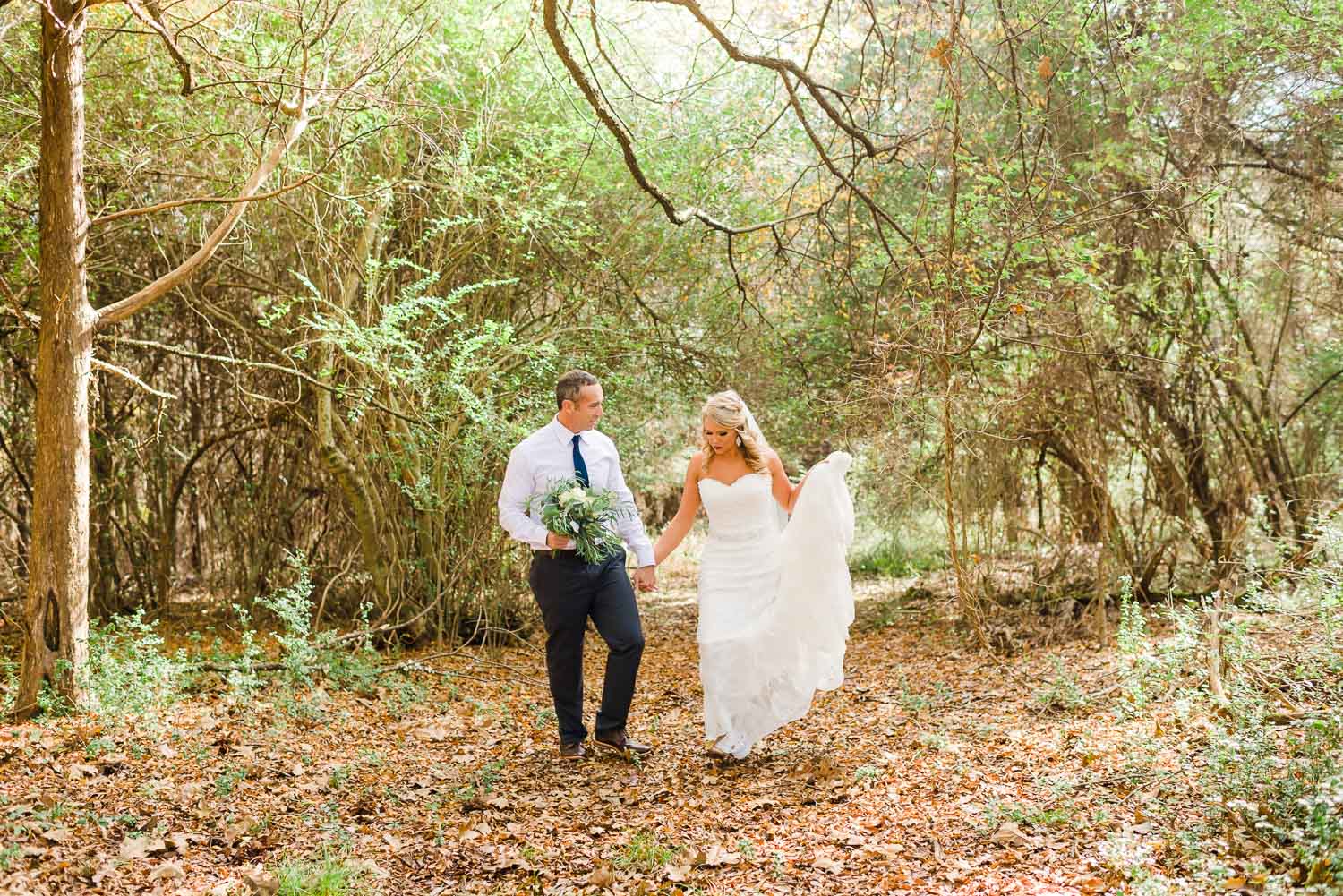 bride and groom walking through the woods at the Barn at Drewia Hill