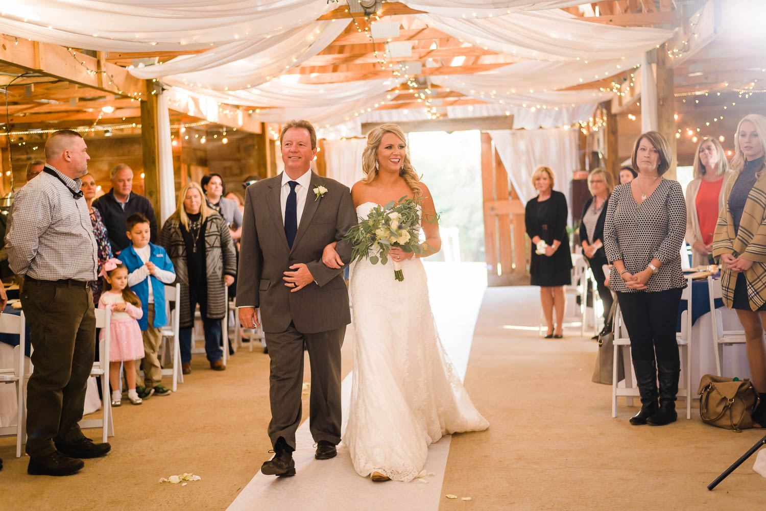 bride walking down the aisle with her dad and stealing a glance over at her mom