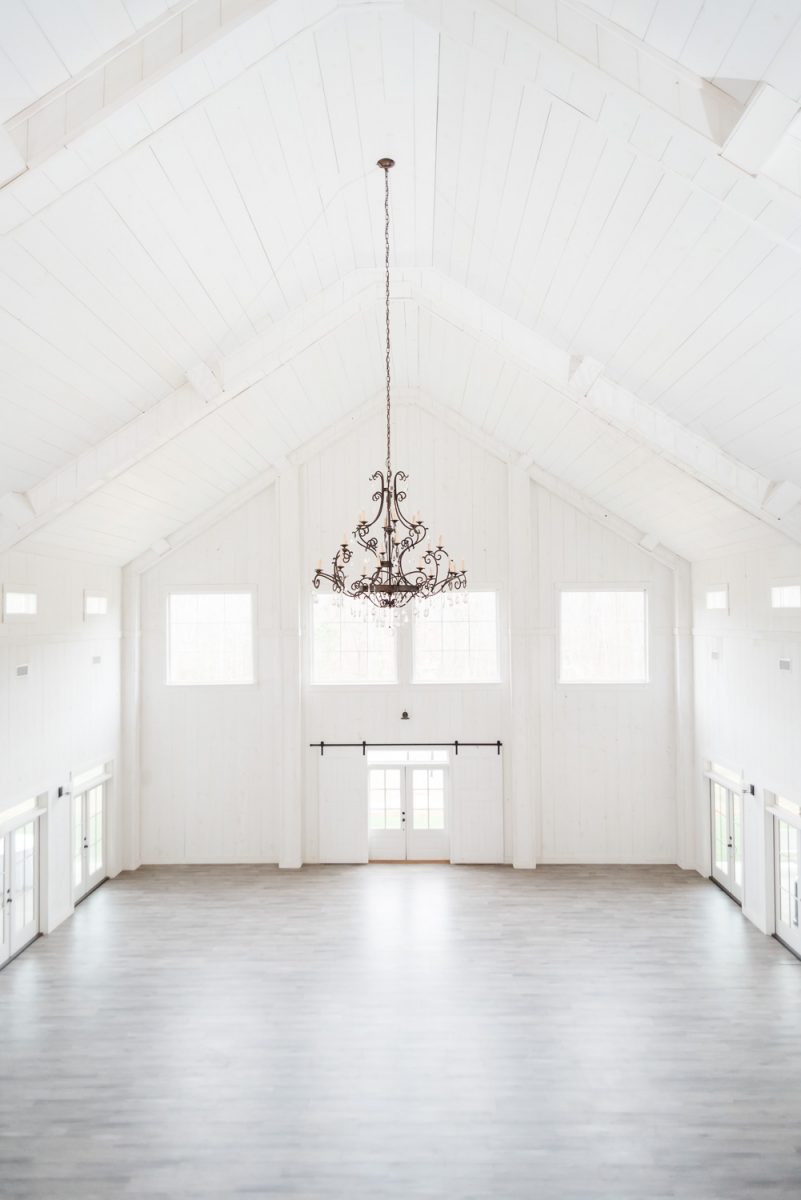 interior of Circle B Events with it's white walls and white ceiling and leage chandelier
