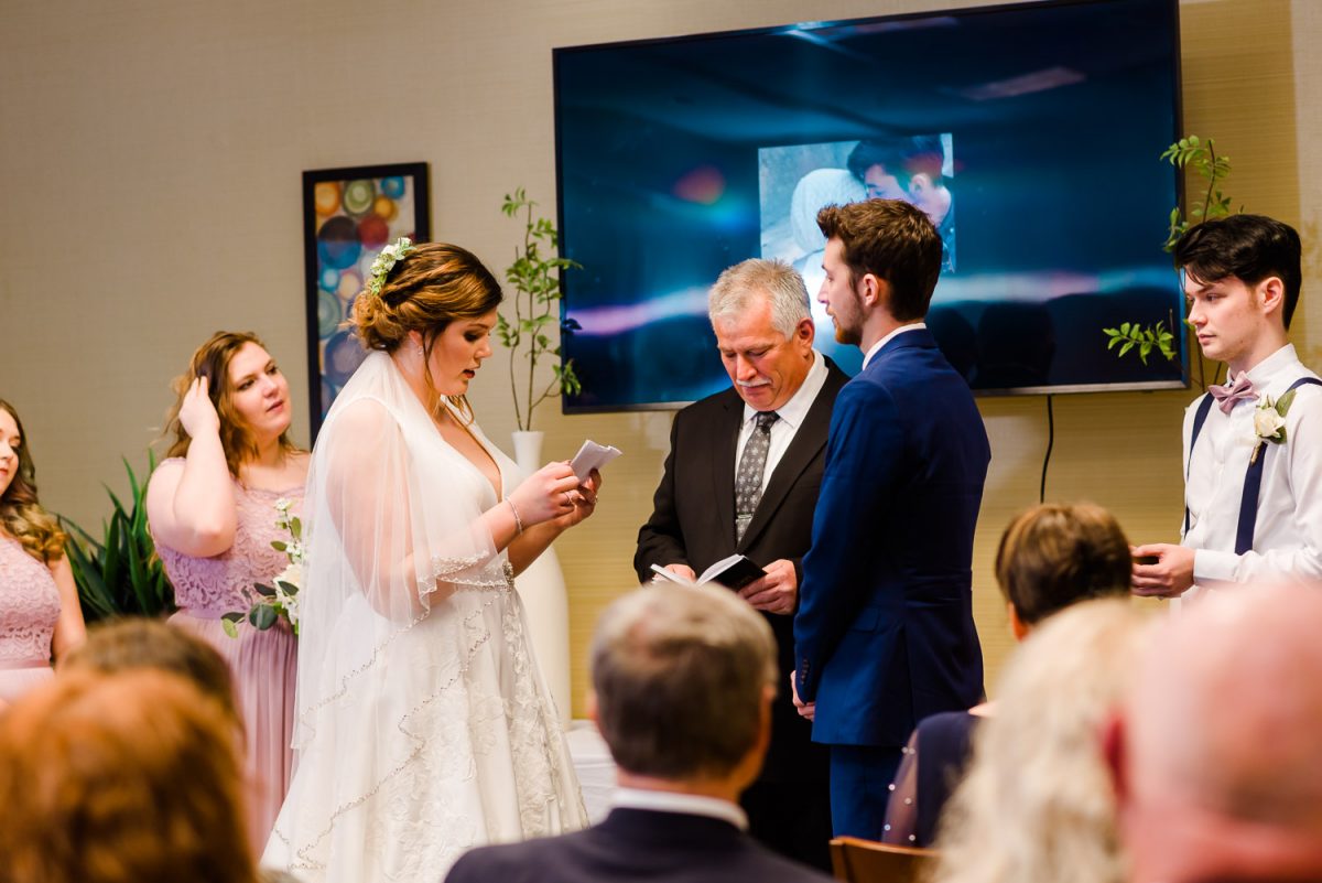 bride reading her wedding vows at the indoor wedding ceremony