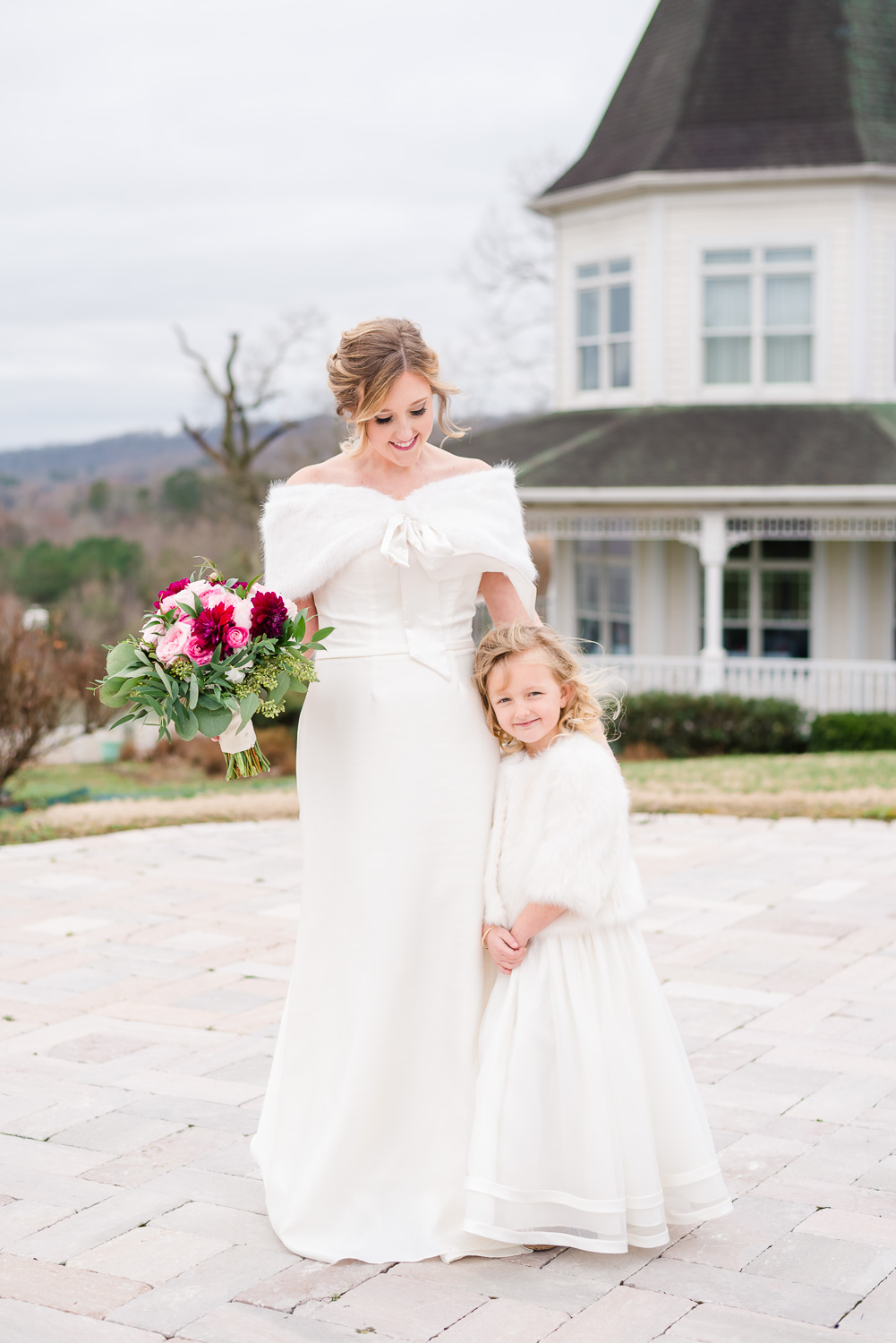 adorable flower girl and bride looking down at flower girls outside on the stone patio at Whitestone inn.