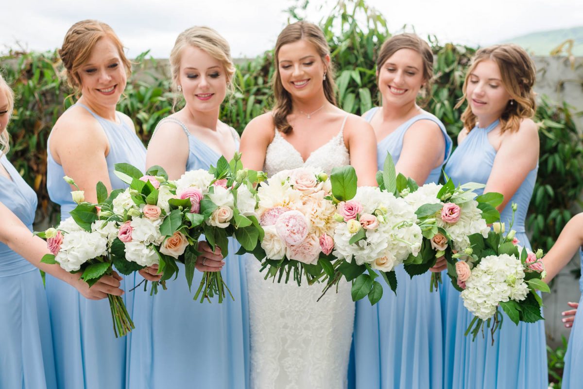 WEDDING BOUQUESTS MADE FROM PINK PEONIES, AND WHITE ROSES in front of ice blue dresses