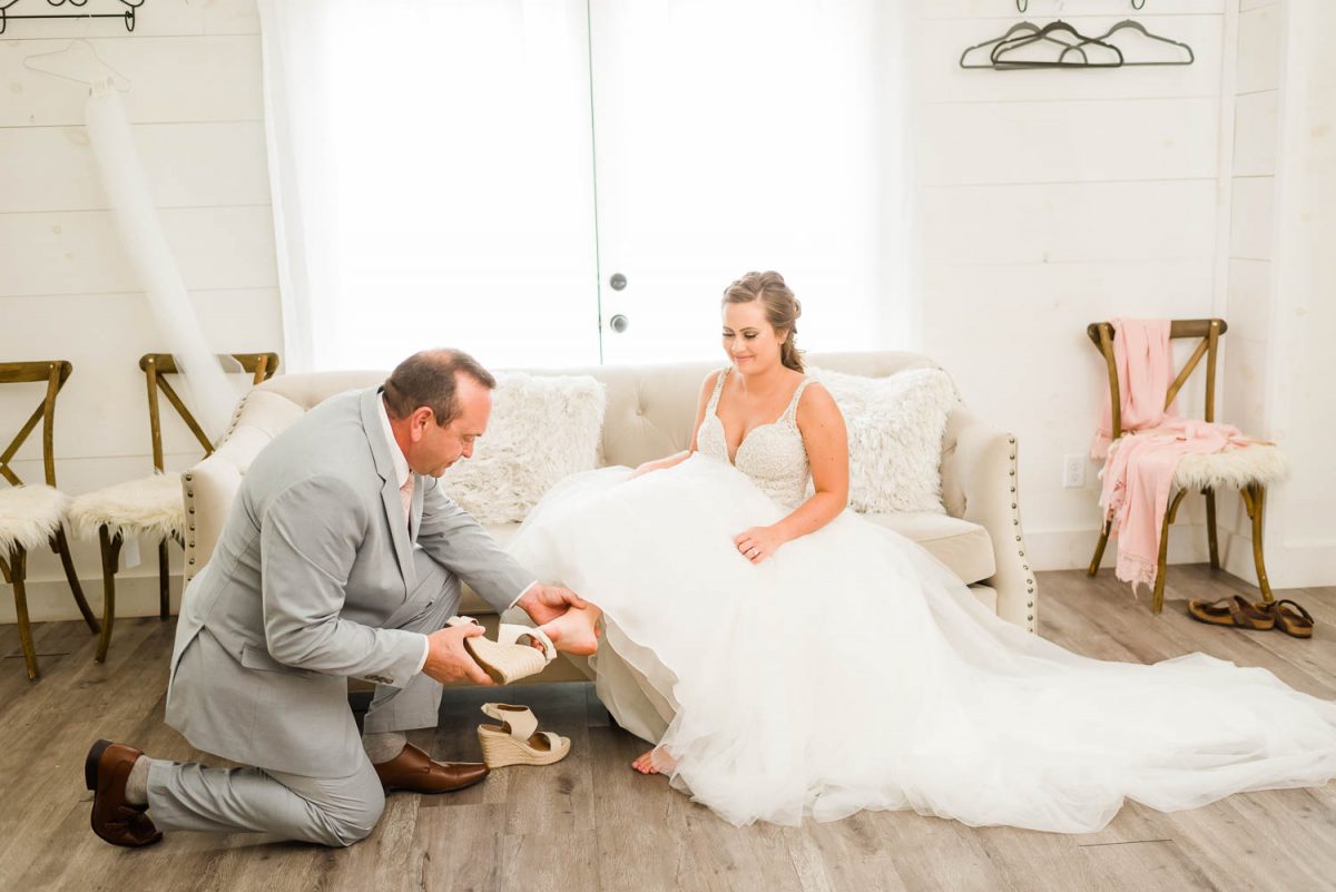 bride's dad putting on her shoes