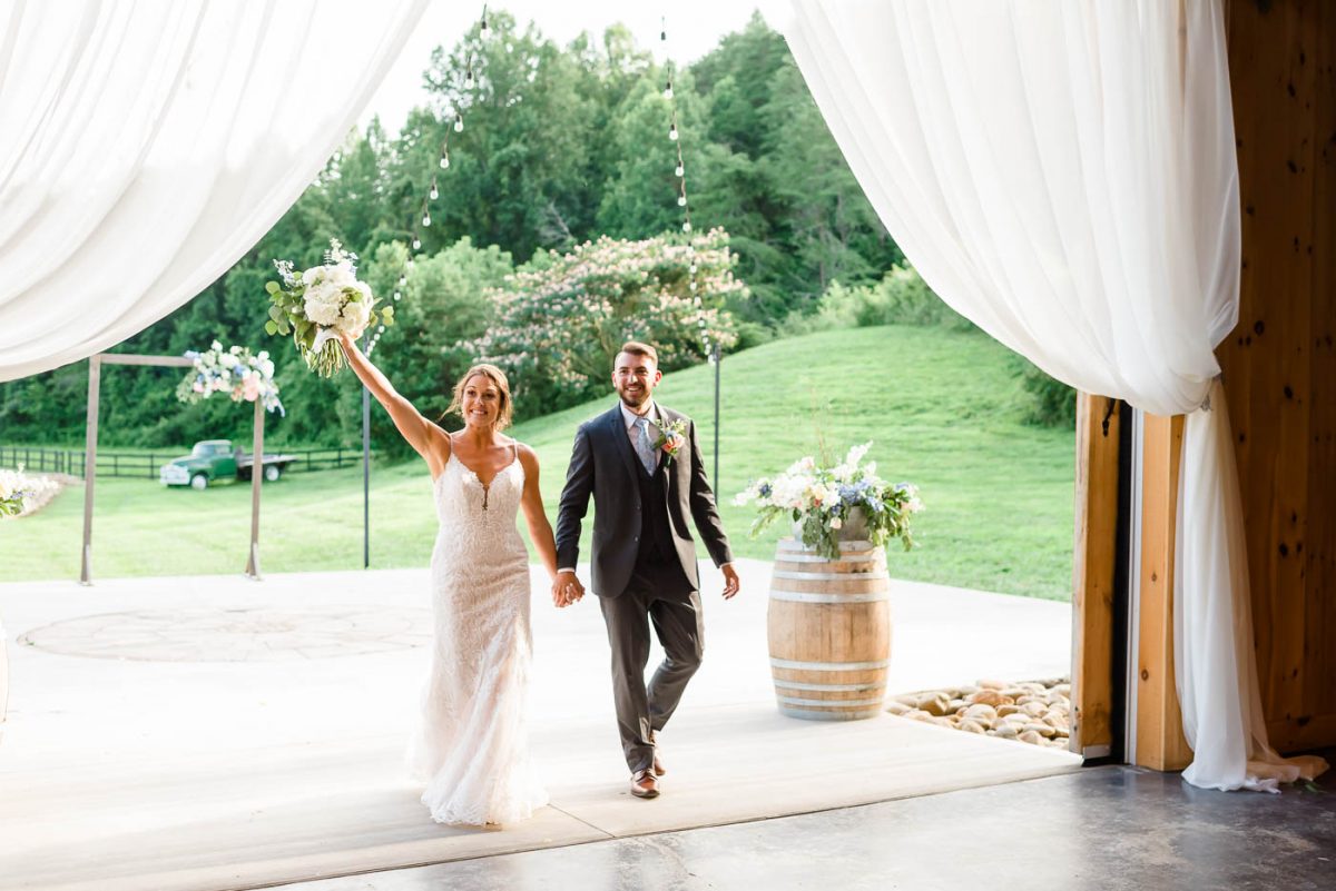 bride and groom walking in open barn door