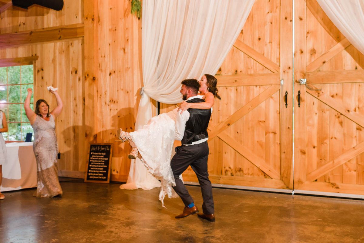 groom carrying bride off of dance floor