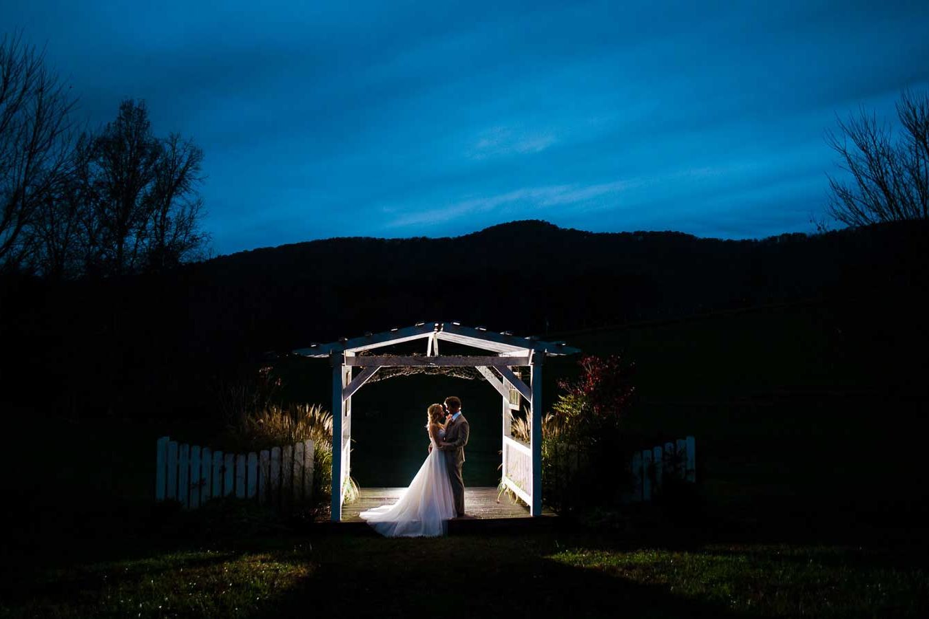 bride and groom untaer pergola at Sampsons hollow at night for wedding portraits