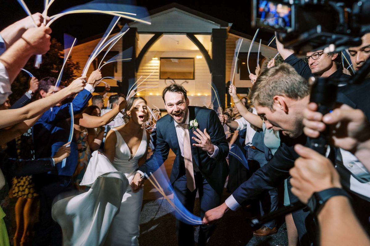 Bride and Groom Gracefully Exit Under a Foam Glow Stick Arch
